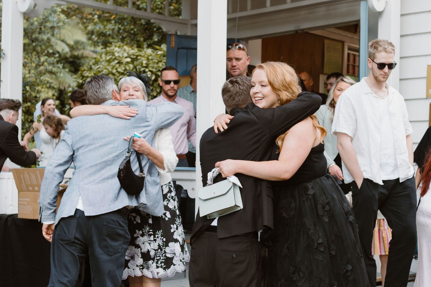 Emotional guests embrace during a joyful moment at the wedding reception.