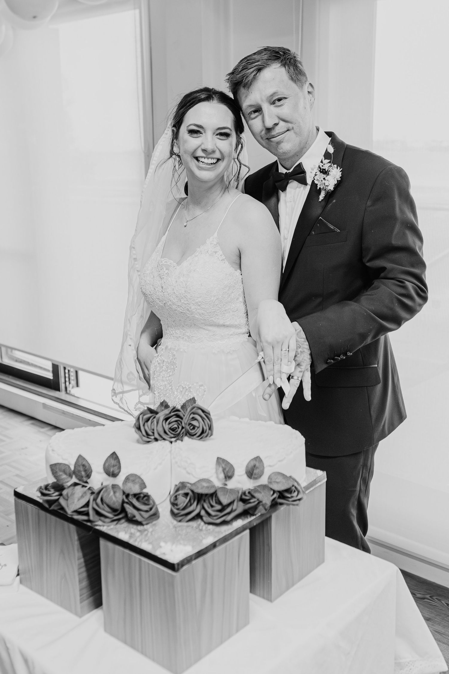 Four sequential frames show a bride and groom in formal wedding attire viewing and reacting to their wedding cake together.