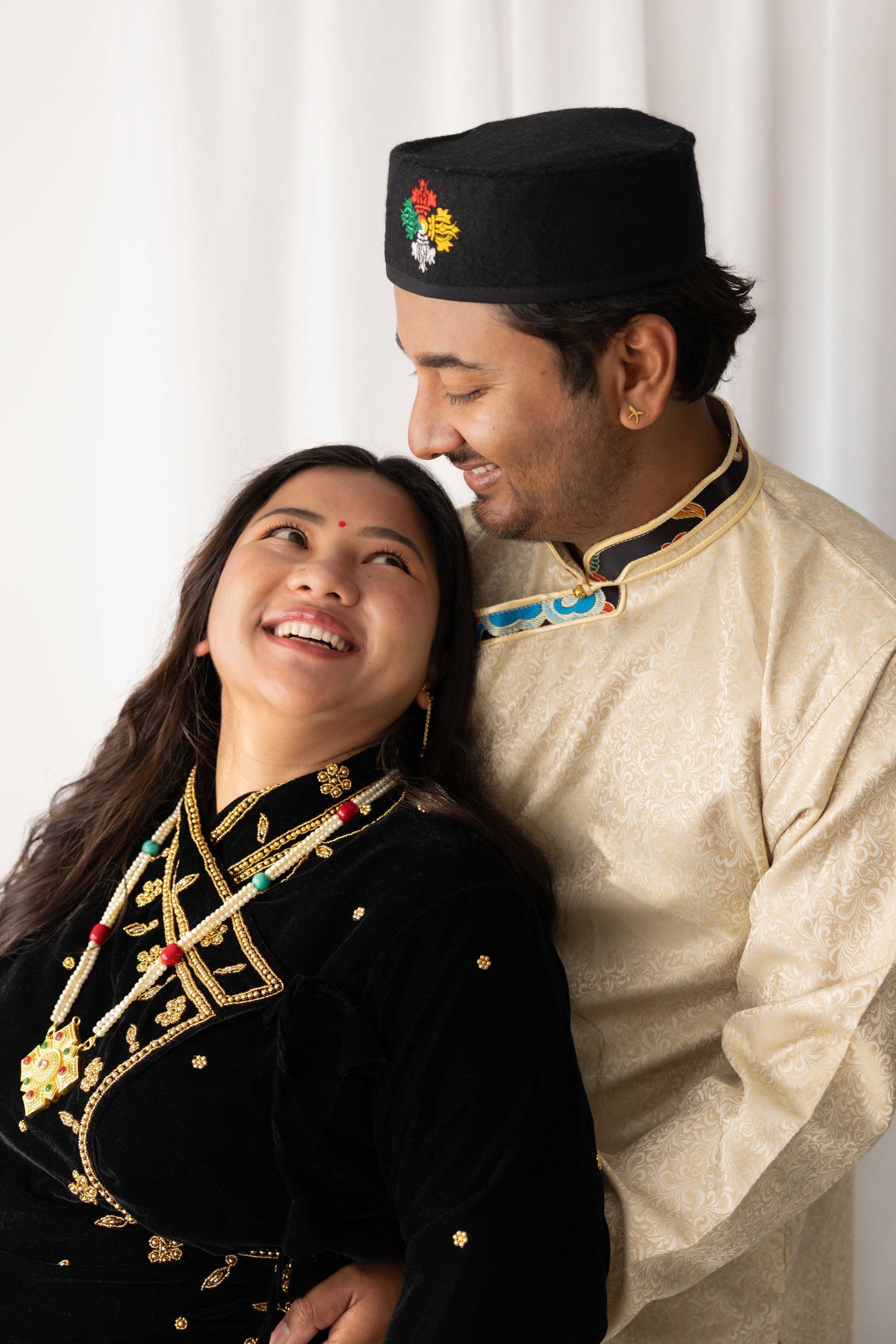 A series of romantic engagement photos showing a couple in black military-style and cream traditional dress posing together.