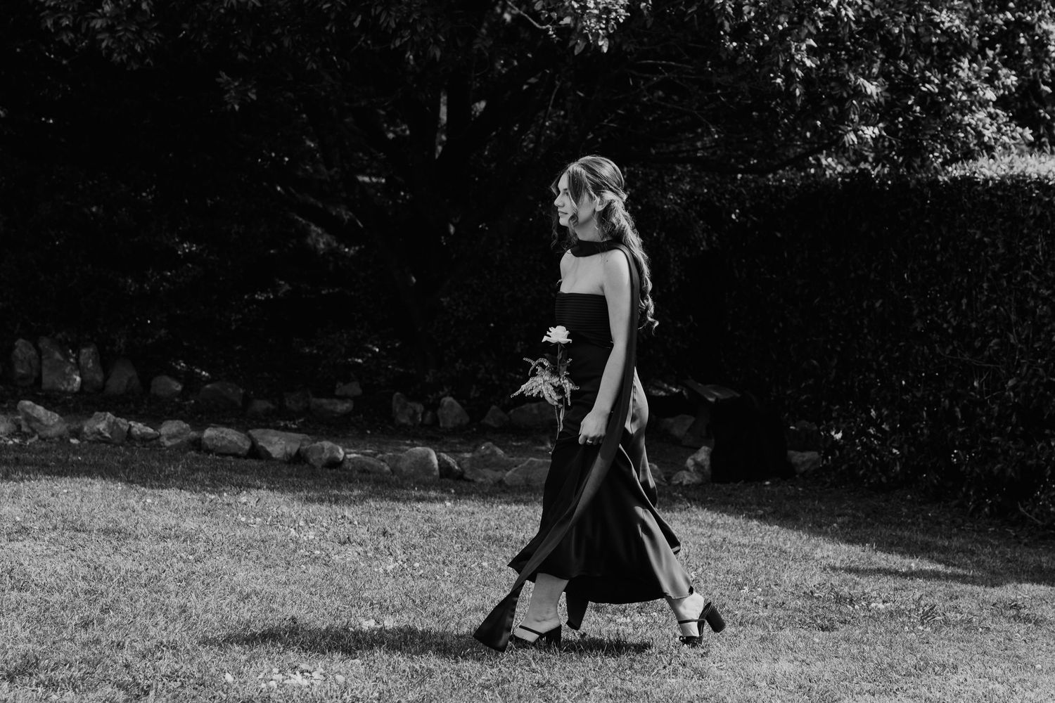 A black and white photo strip showing multiple frames of a person walking with a dog in a park setting.