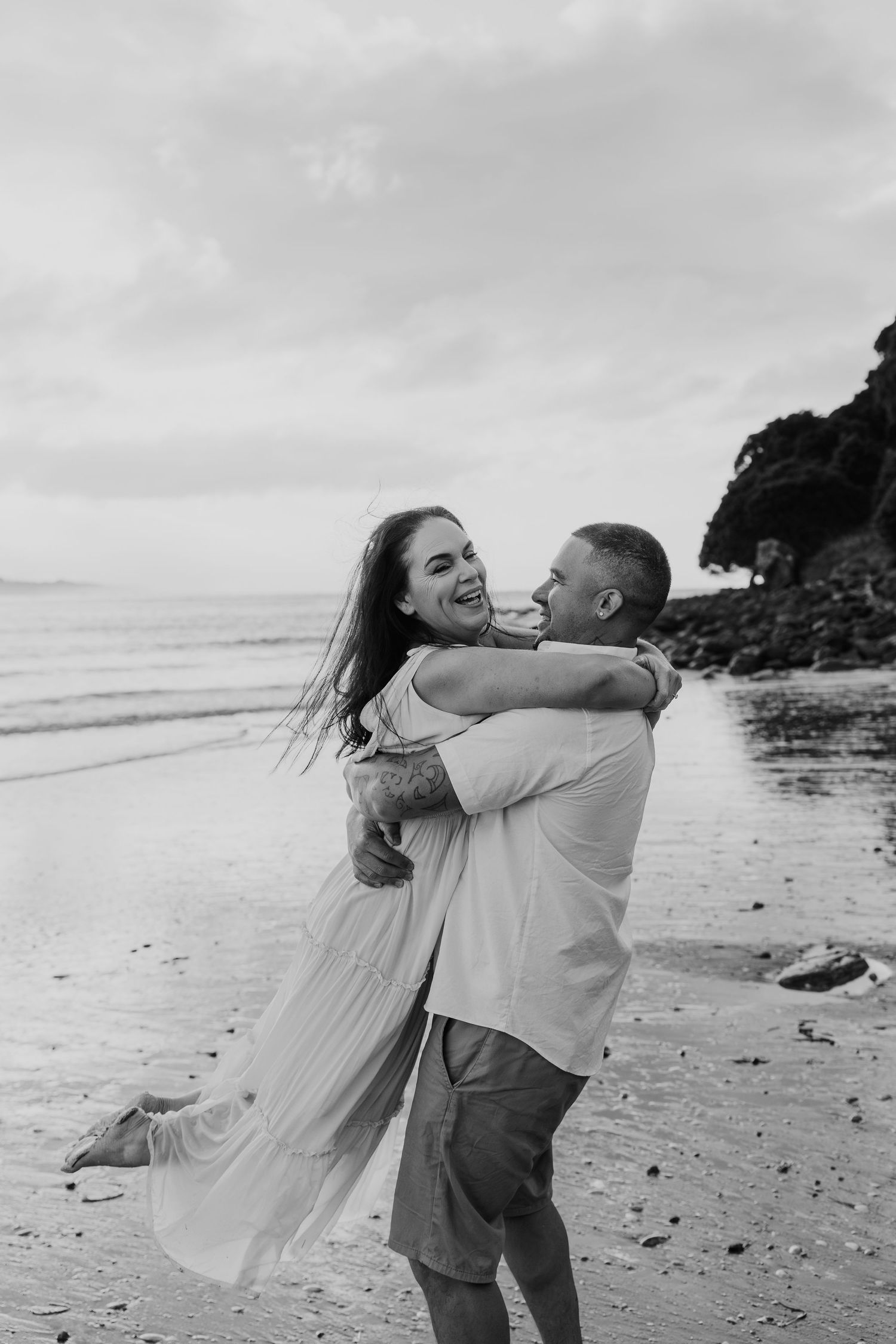 A romantic beach wedding photo sequence shows a couple dancing and twirling together on a cloudy day by the ocean.