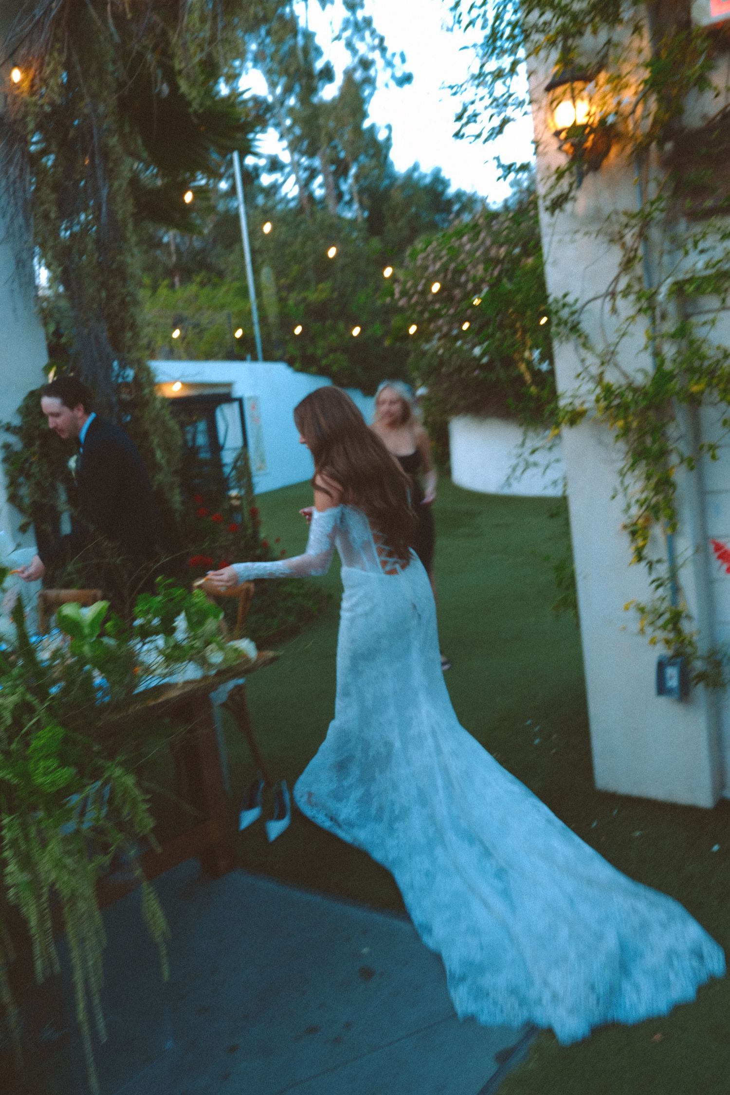 Bride in flowing white dress twirling during an outdoor photoshoot.