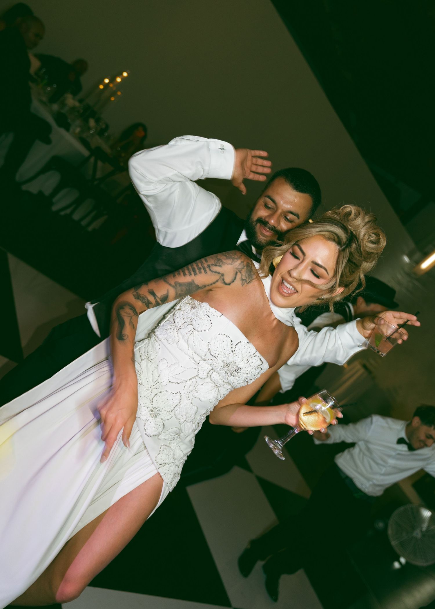 Bride and groom dancing joyfully on wedding reception dance floor.
