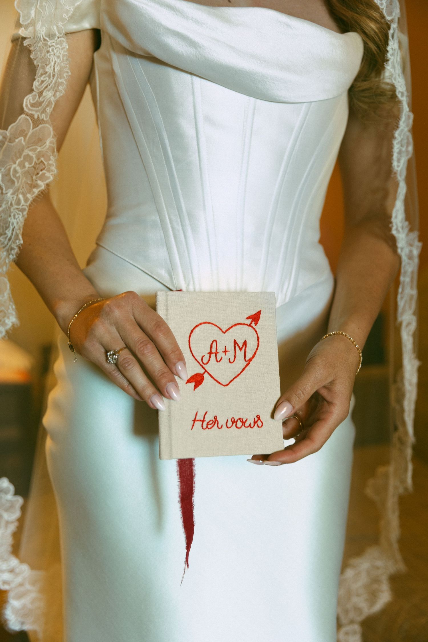 Bride in white corset gown holding a handmade vow book captured by a Southern California wedding photographer before her ceremony