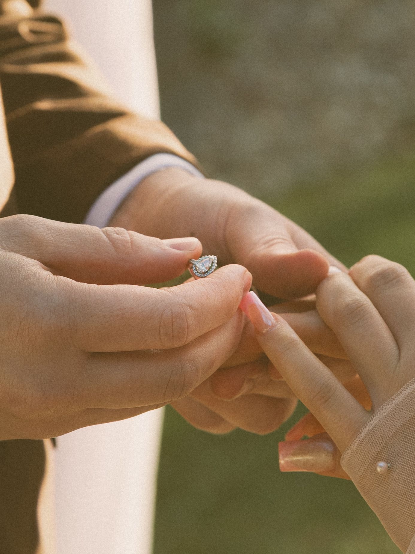 Close-up shot of hands exchanging wedding rings during a ceremony.