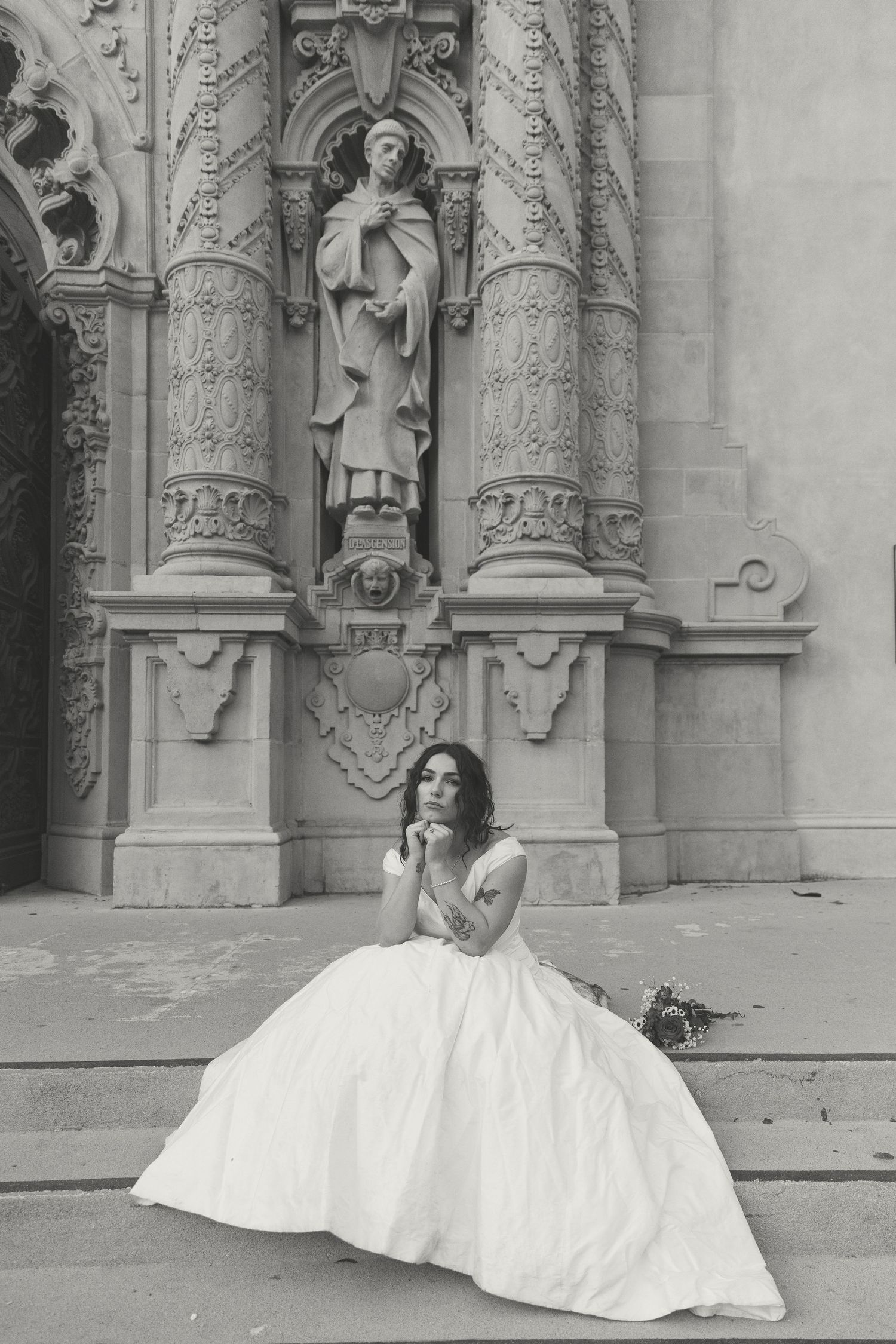 A classic black and white bridal portrait against ornate stone architectural details.
