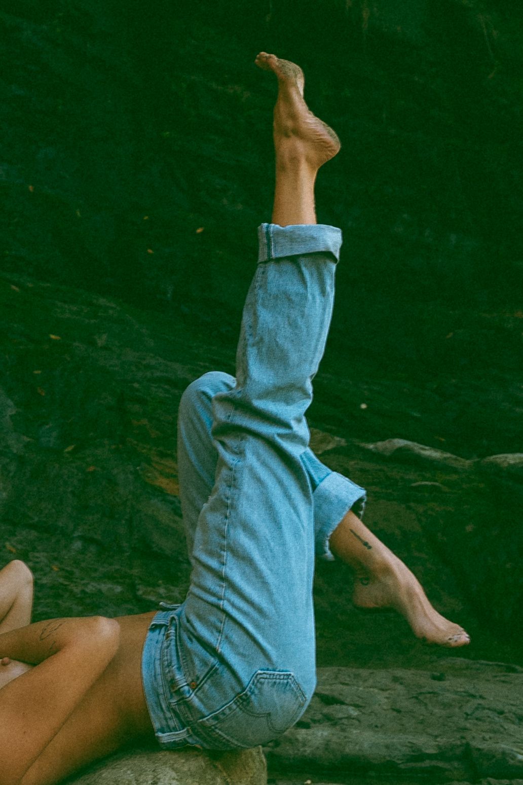 A sequence of photos showing someone tumbling forward in blue denim shorts against a dark background.