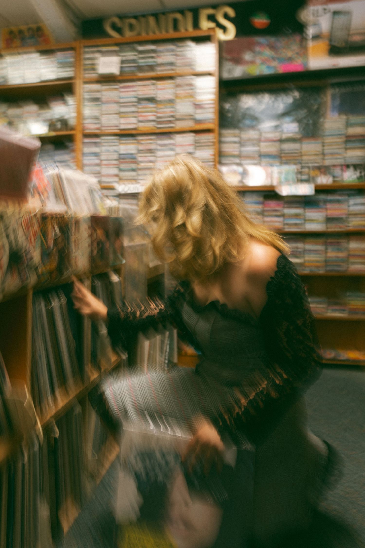 Blurred motion photo showing someone looking through records at a music store called Spindles.
