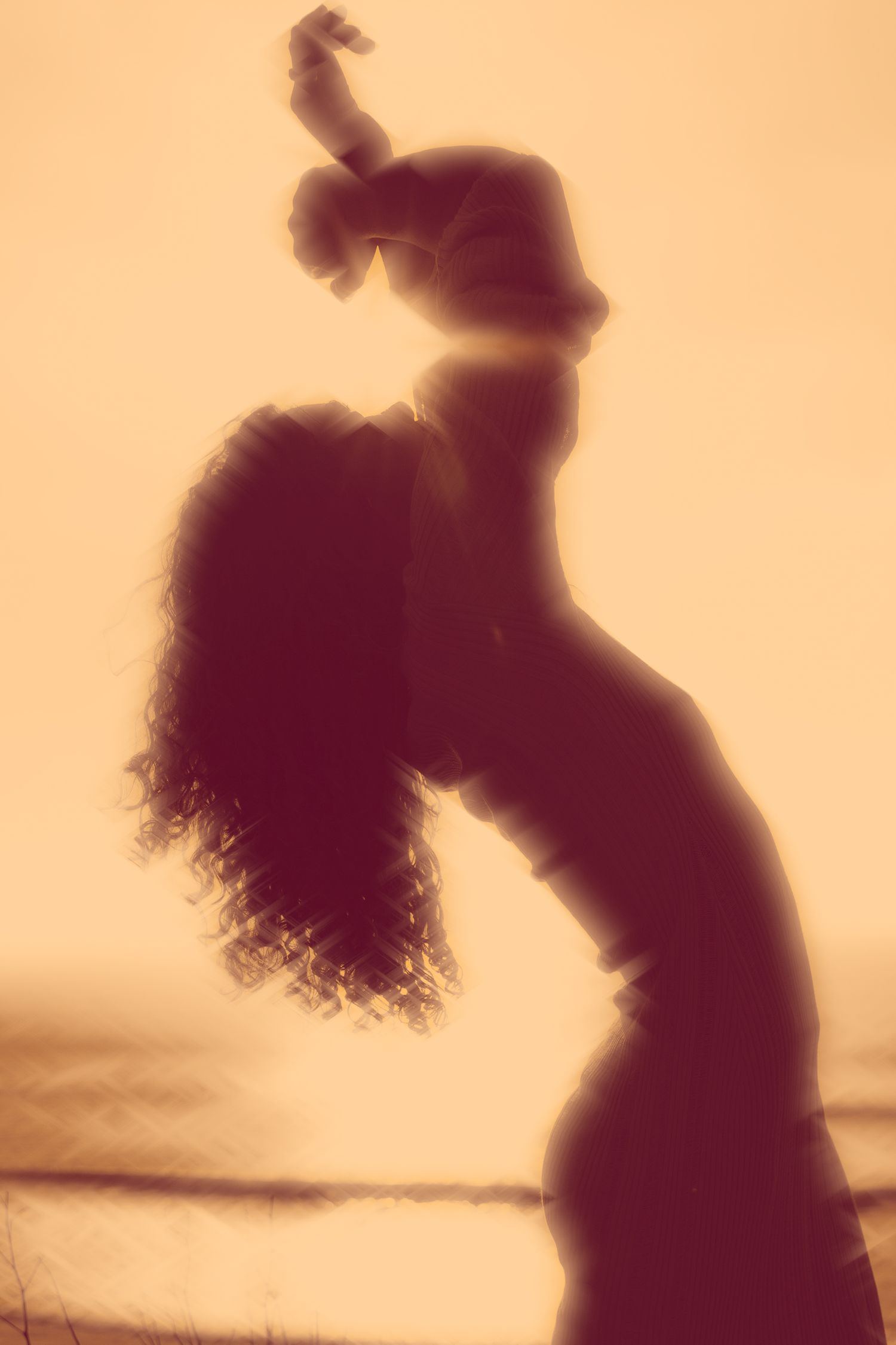 Silhouette photo captures graceful arching pose against warm sunset sky.