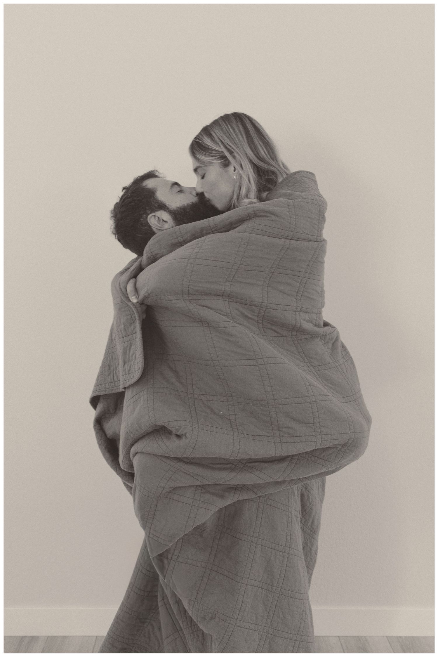 A series of intimate moments captured with a couple wrapped in a gray blanket.