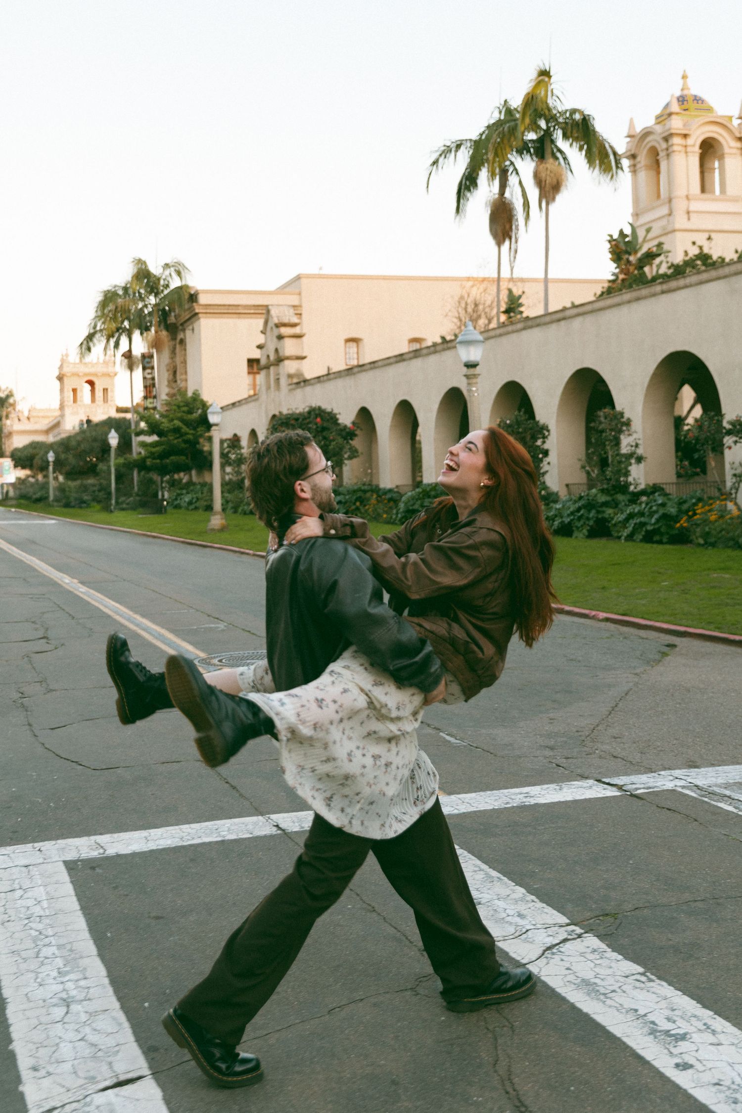 Playful dance moves performed in front of Spanish colonial architecture.