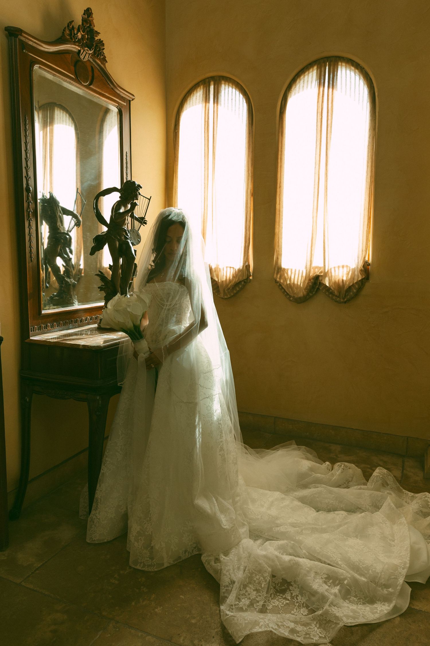 Bride standing by window in her wedding gown, intimate Southern California wedding photography