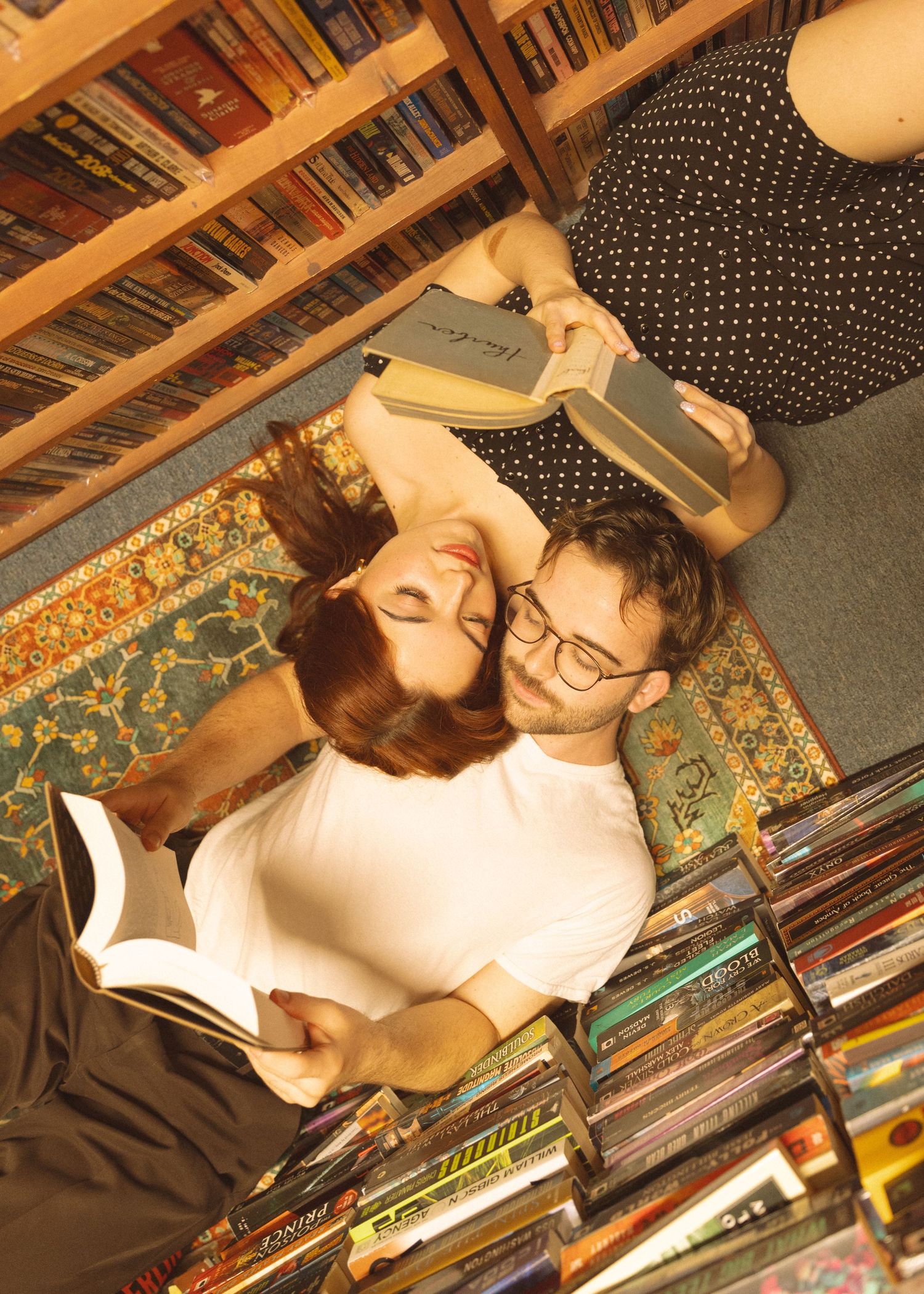 Couple relaxing together among library bookshelves in a casual setting.