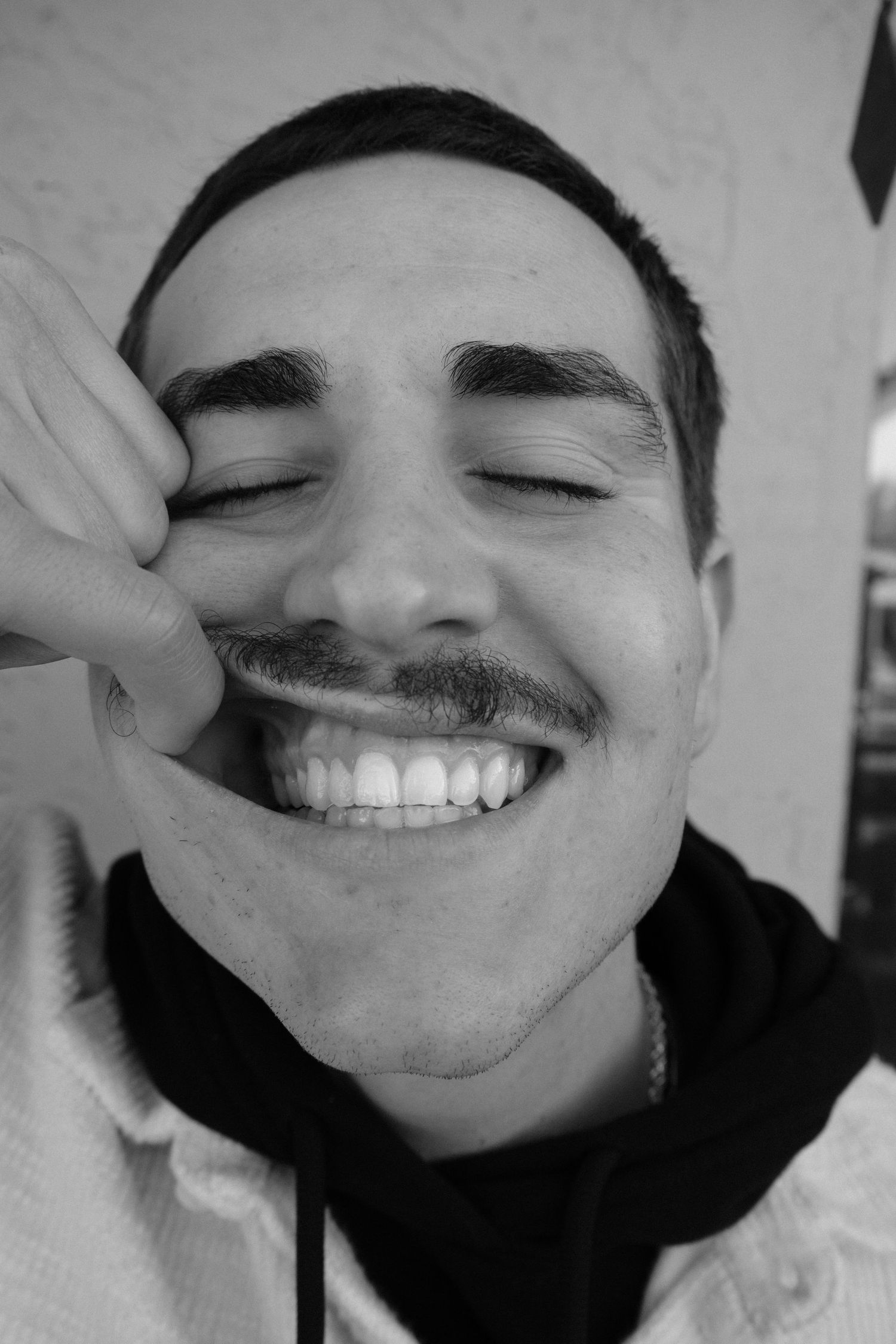 Close-up black and white portraits showing playful facial expressions.