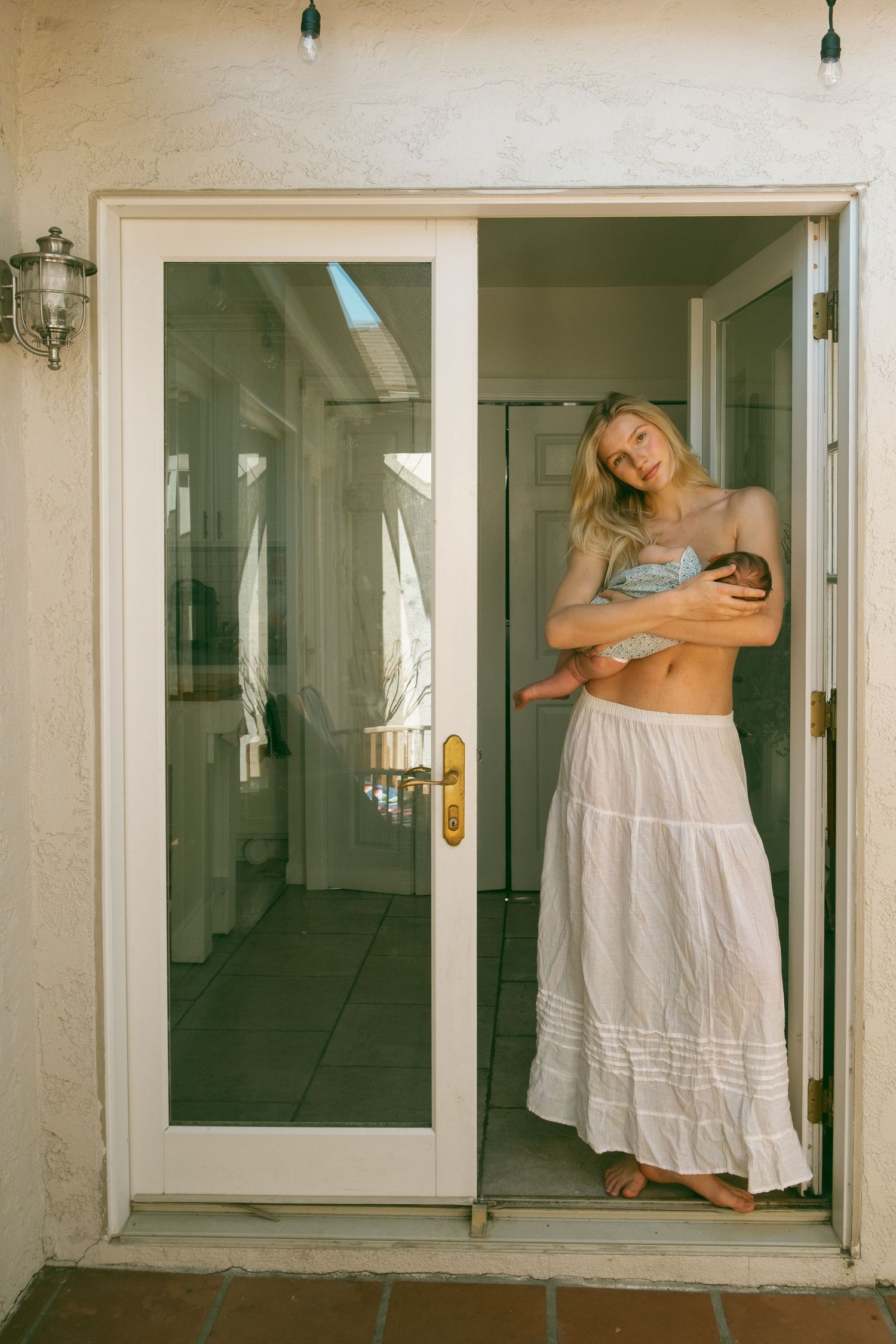 Ethereal dance-like movements captured in white dress against minimalist interior backdrop.