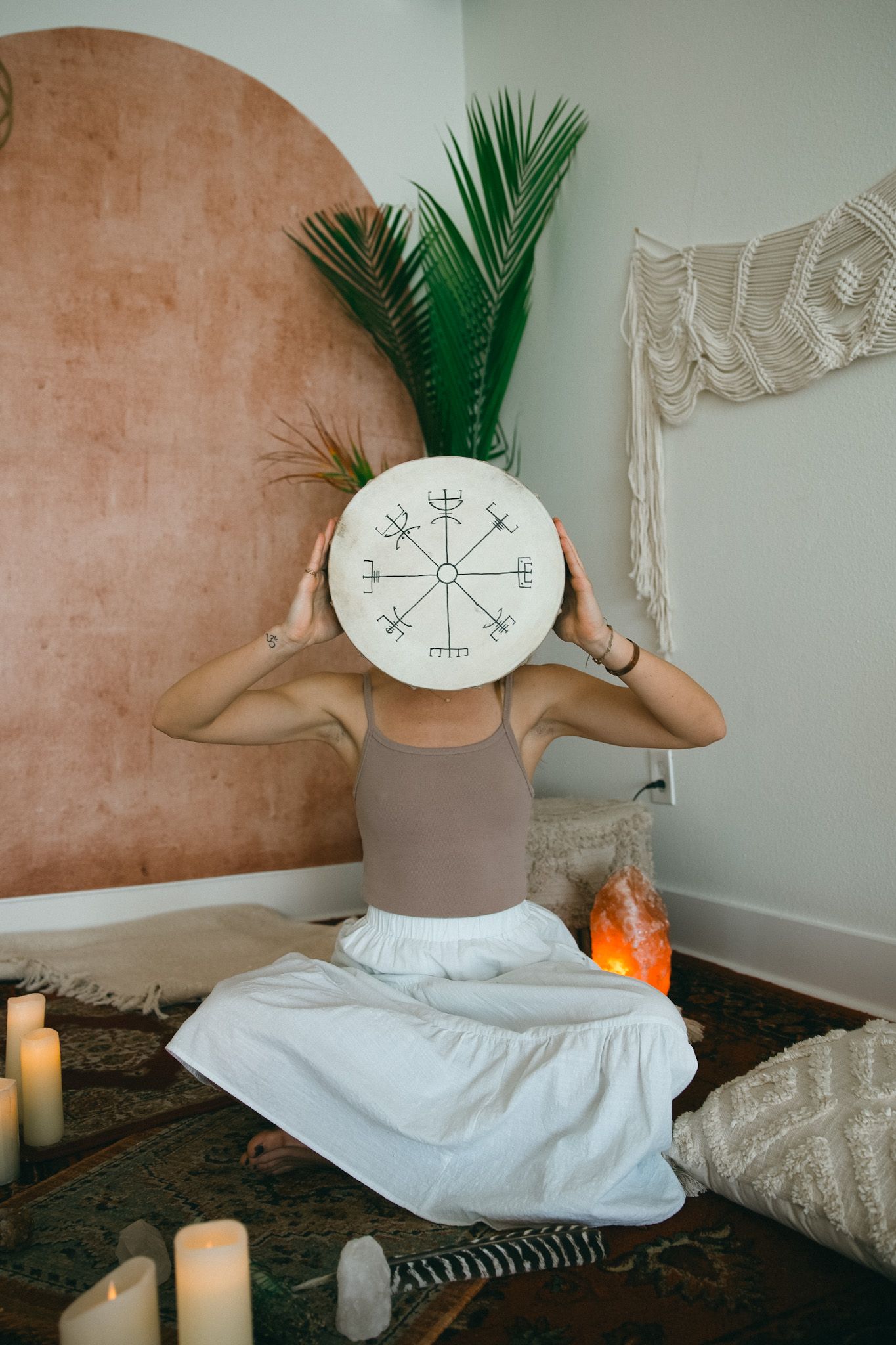 Meditation area featuring mystical symbols, candles and bohemian decor elements.