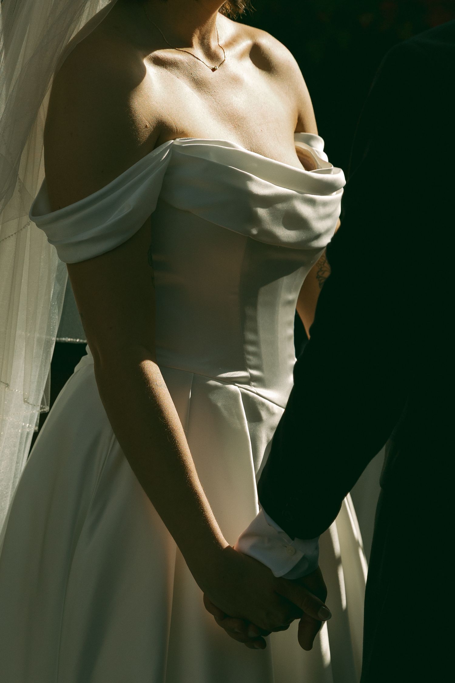 Artistic close-up shots of wedding dress details in dramatic lighting.