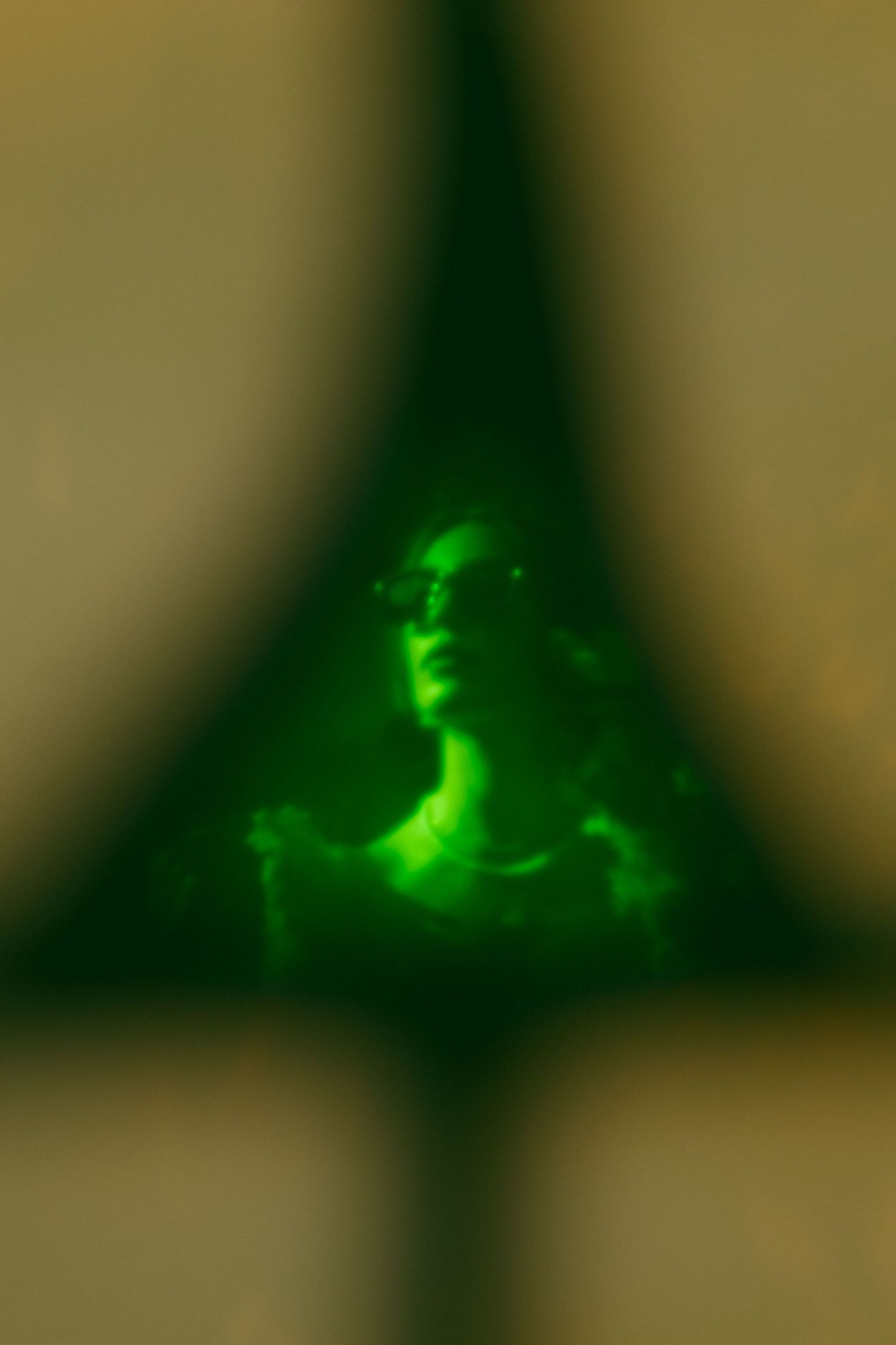 An artistic green-tinted portrait with ethereal lighting effects.