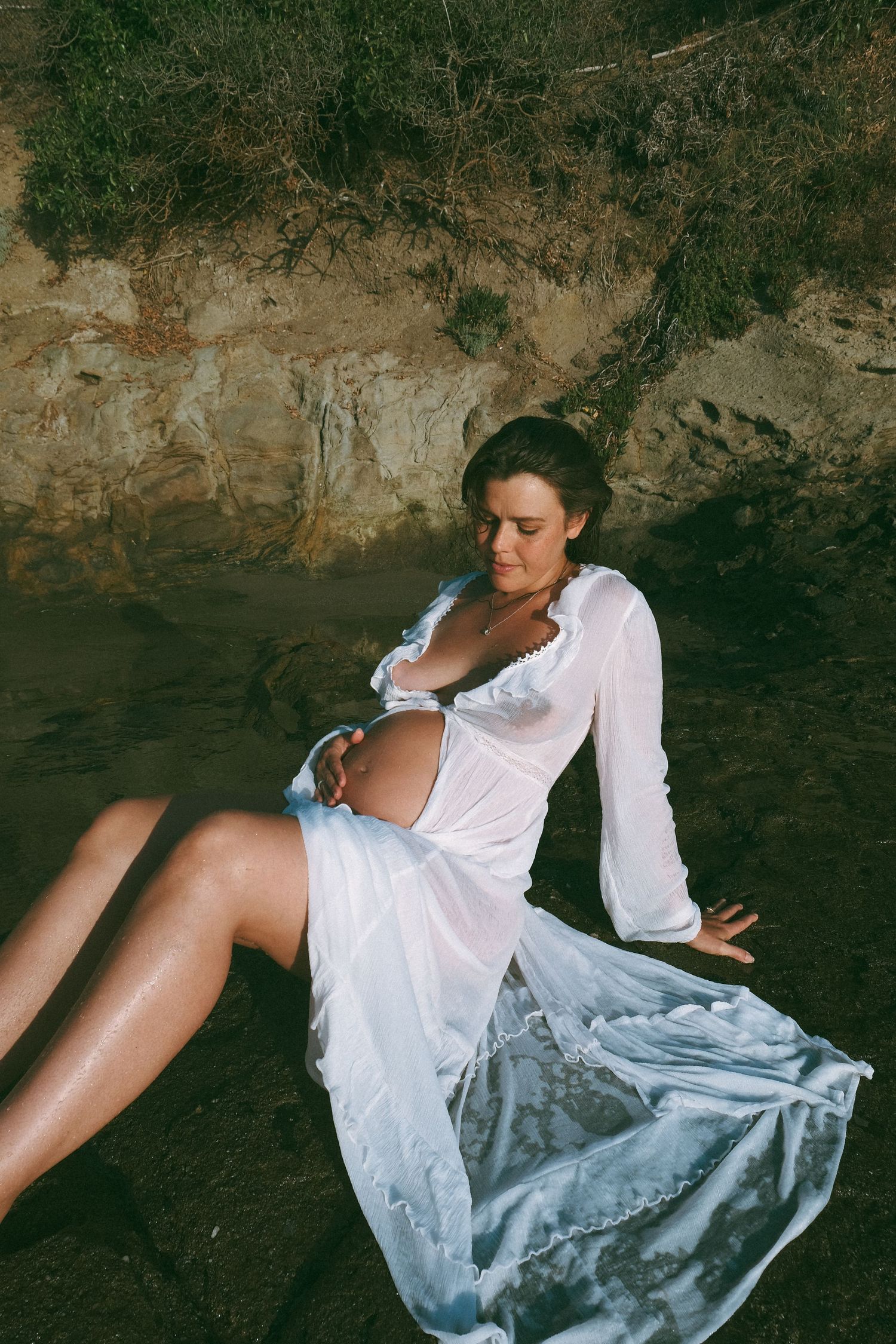 Artistic sequence showing movement in white flowing dress against textured cave wall.