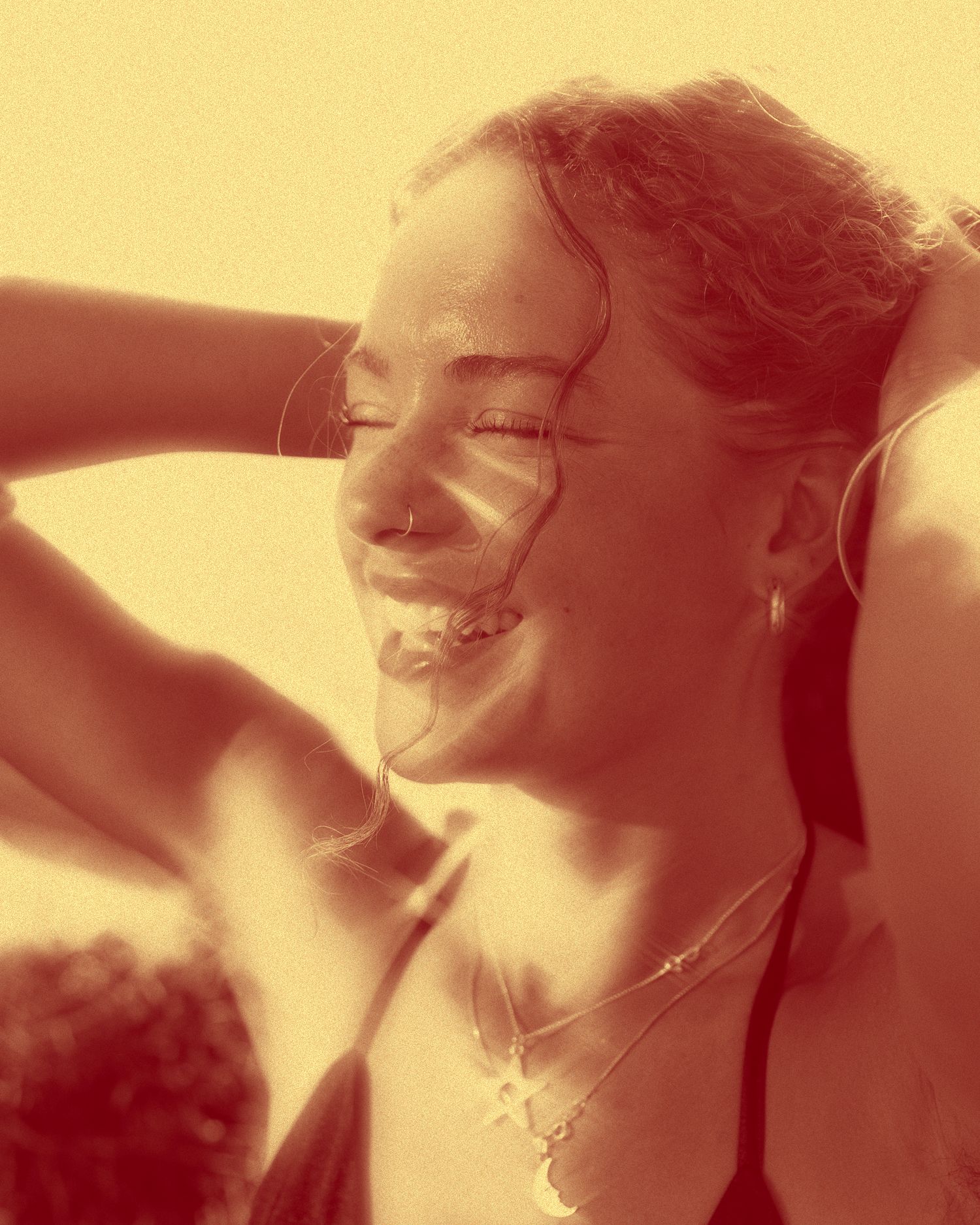 Warm-toned closeup portrait capturing joyful expression in natural sunlight.