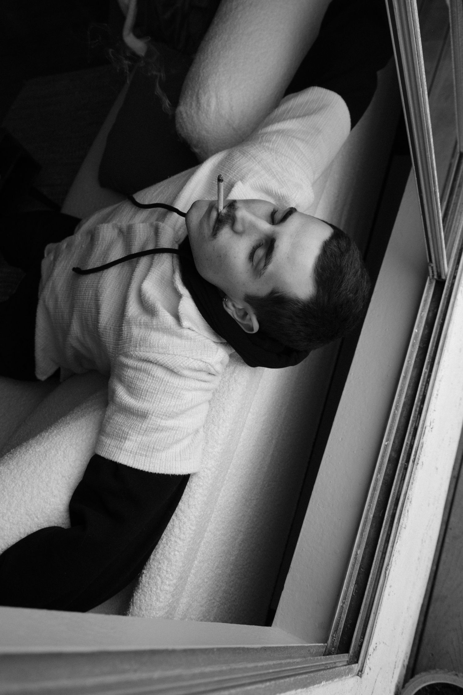 Dramatic black and white portraits showing contemplative poses near window.