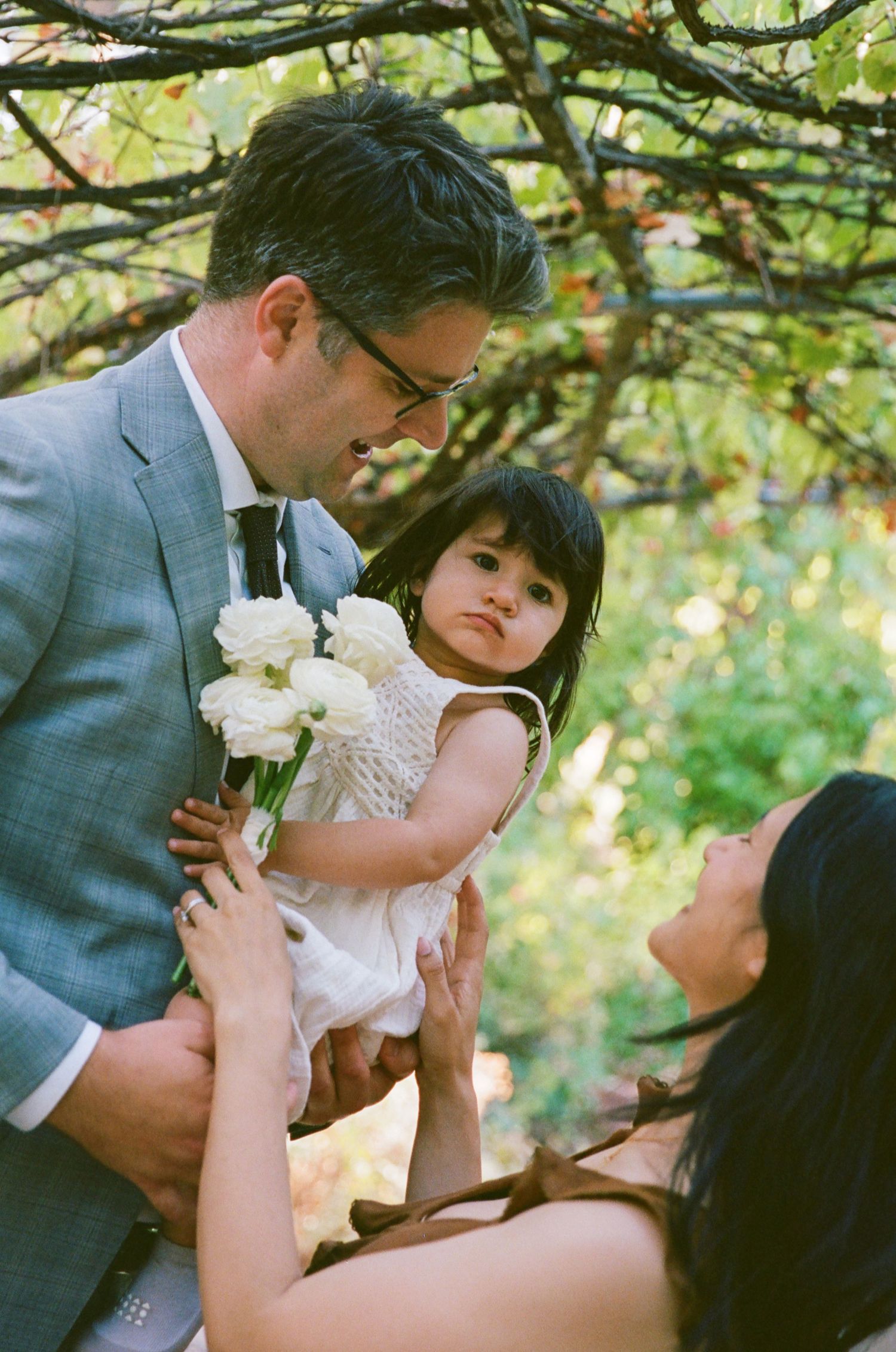 Wedding photographer in San Diego capturing a sweet candid family moment during an outdoor wedding celebration