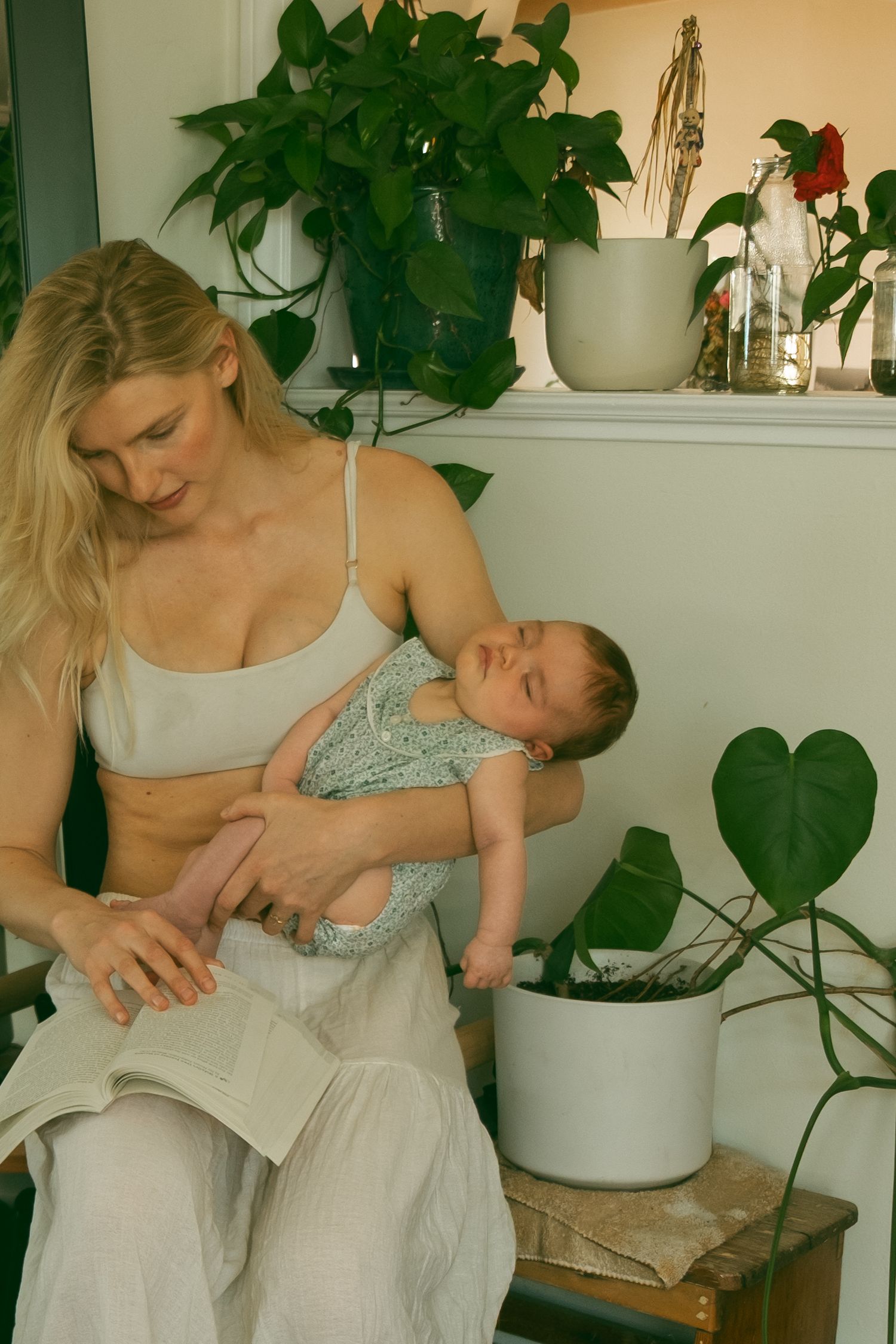 Tender moments captured in a bright room with houseplants and white decor.