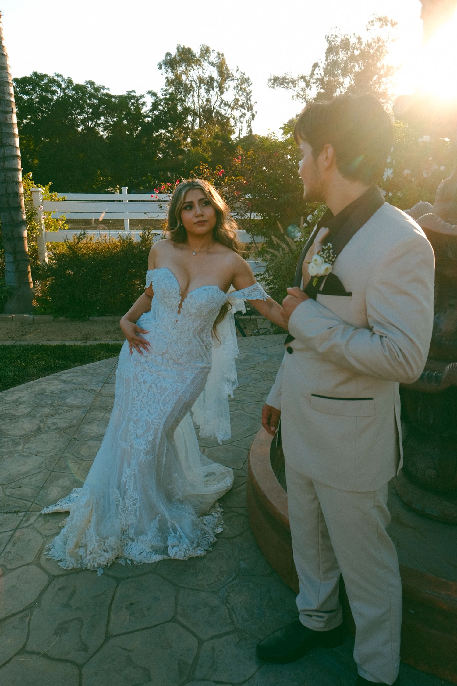 Wedding couple dancing together outdoors on stone patio at sunset.