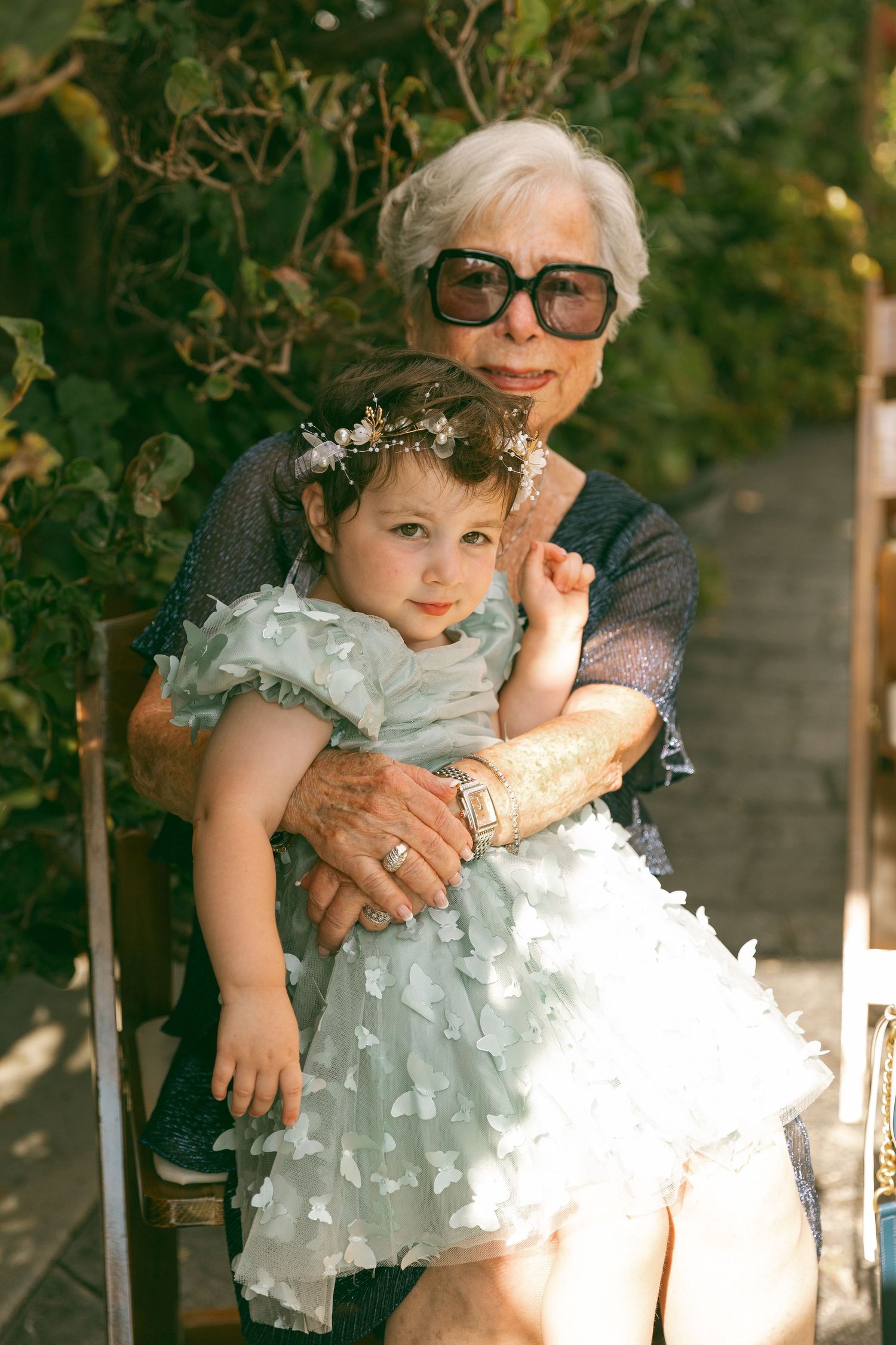 Sweet moments between a flower girl in a ruffled dress and wedding guests outdoors.