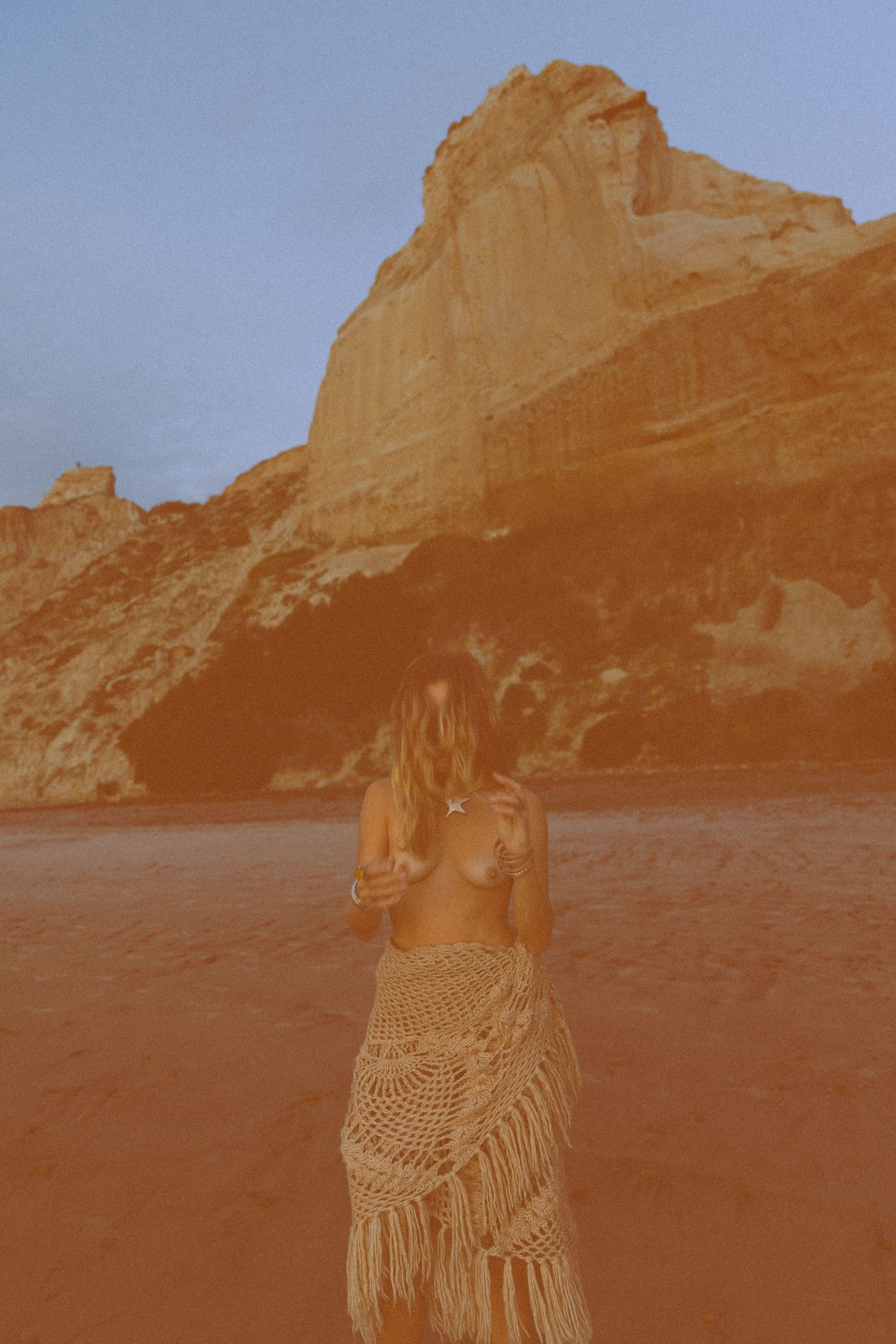 A series of vintage sepia-toned photographs showing a figure in a crochet dress posing against desert rock formations.