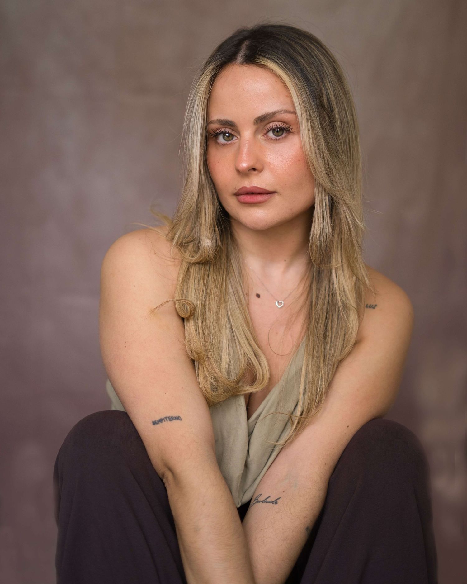 A series of studio portraits showing a person with blonde hair in a dark top against a brown backdrop.