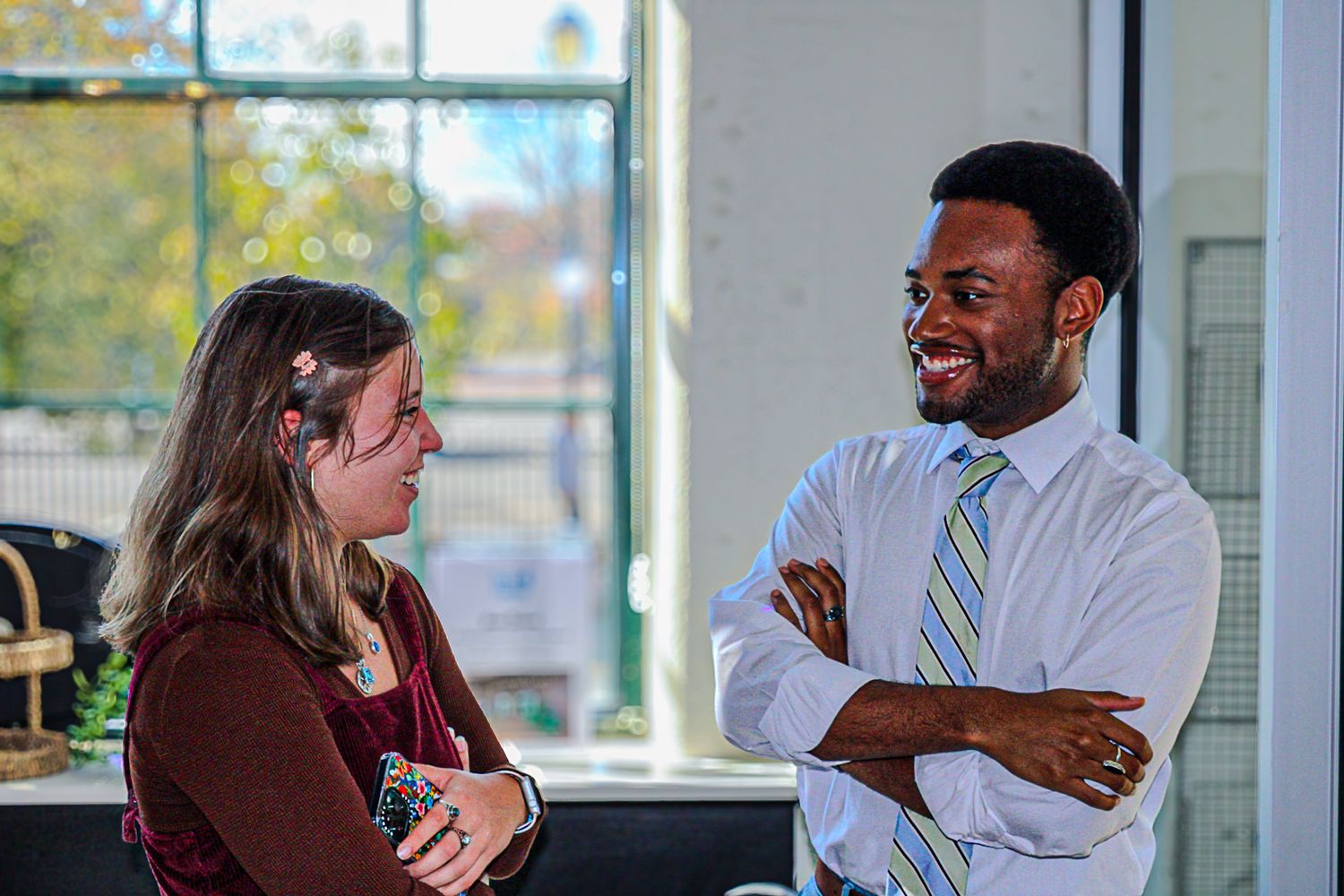 Two people engaged in friendly conversation in a bright indoor setting.