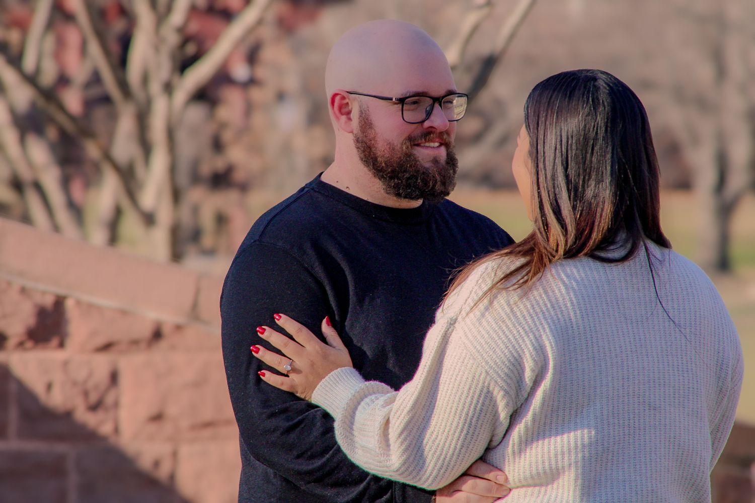 A couple shares an intimate moment during their engagement photoshoot in an outdoor setting.