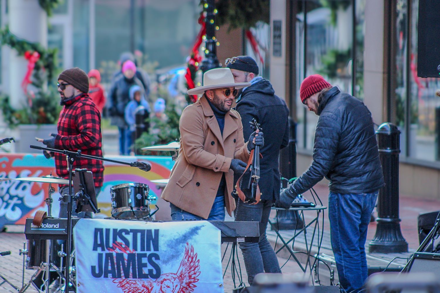Musicians performing at an outdoor event with Austin James signage visible.