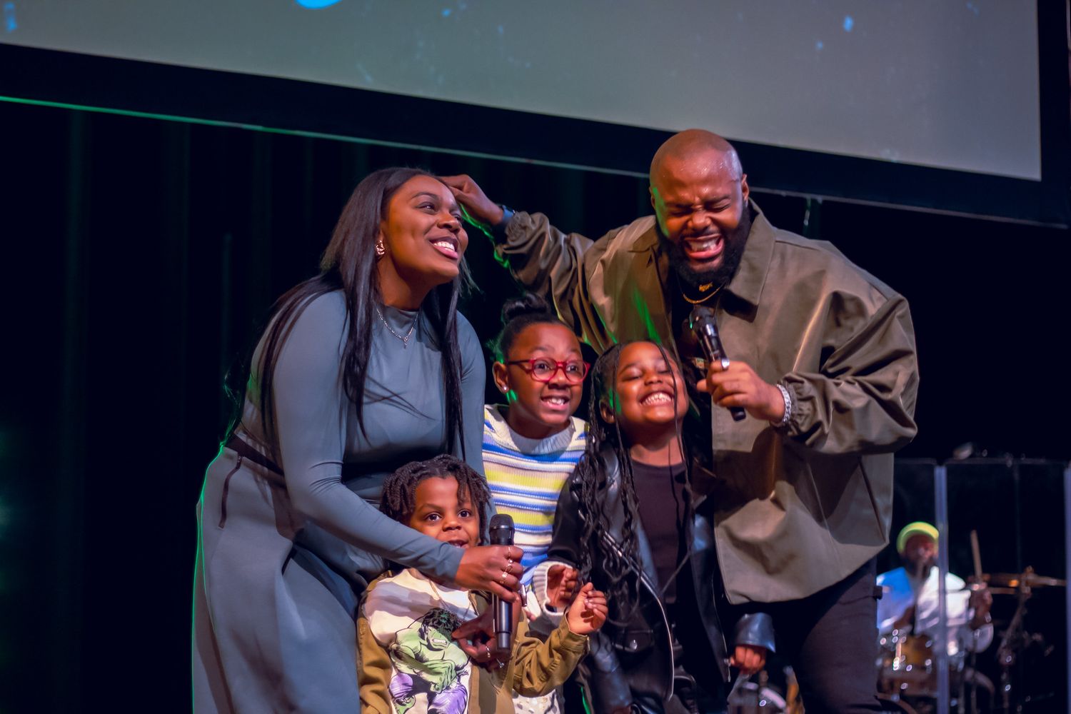Family sharing joyful moment together on stage during performance event.