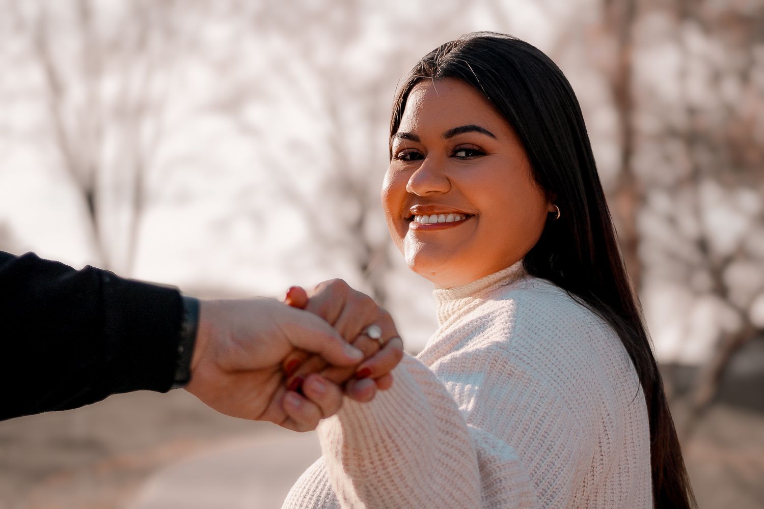 A candid moment of joy captured during a winter engagement photoshoot.