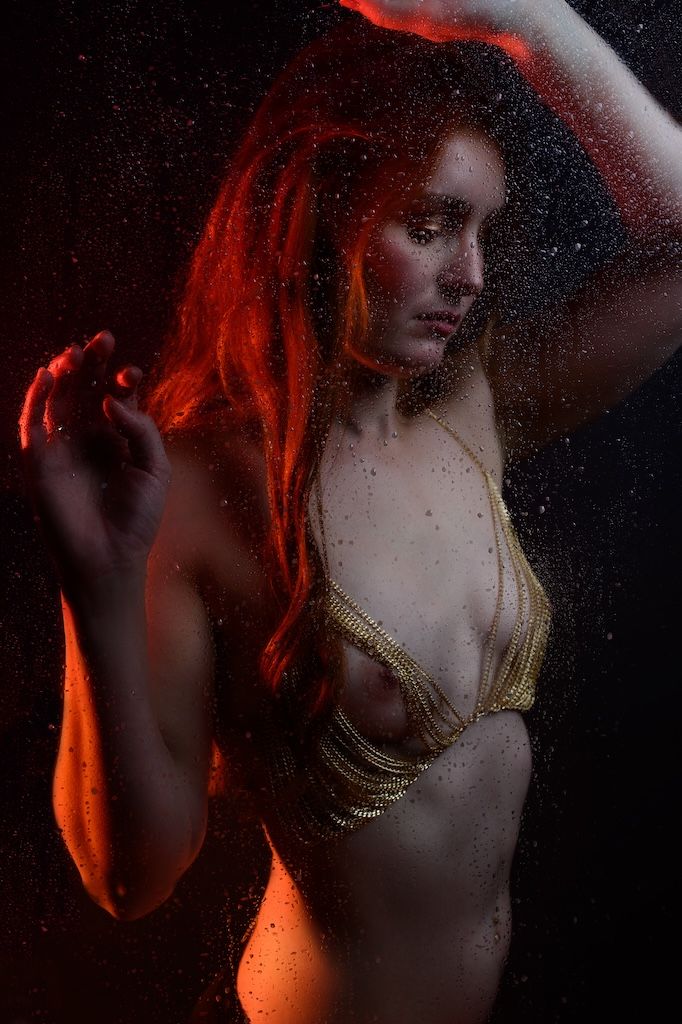 Artistic portrait series showing dramatic red lighting and shadows on a figure in a dark setting.