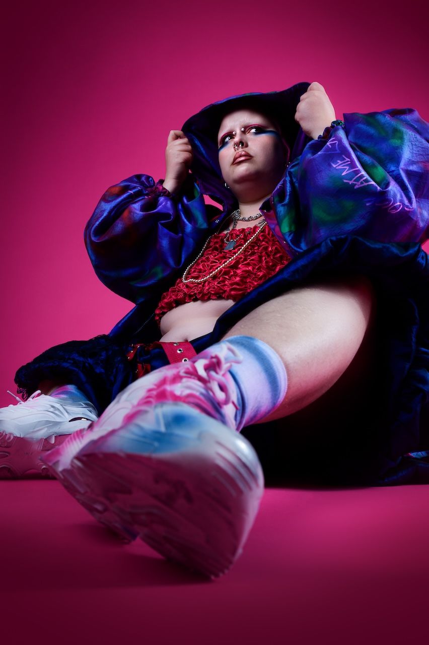 Fashionshoot in Zeewolde, vrouw op grond voor roze achtergrond