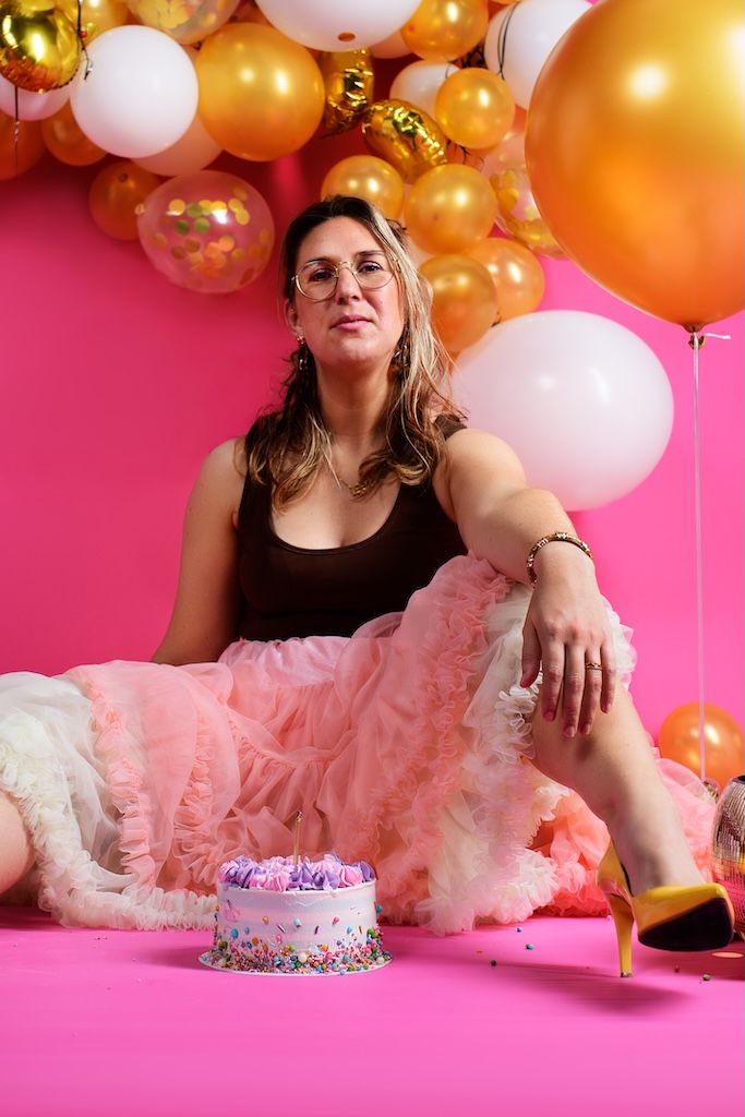 Cakesmash voor volwassenen in Zeewolde. Vrouw met taart en ballonnen en hand op de knie