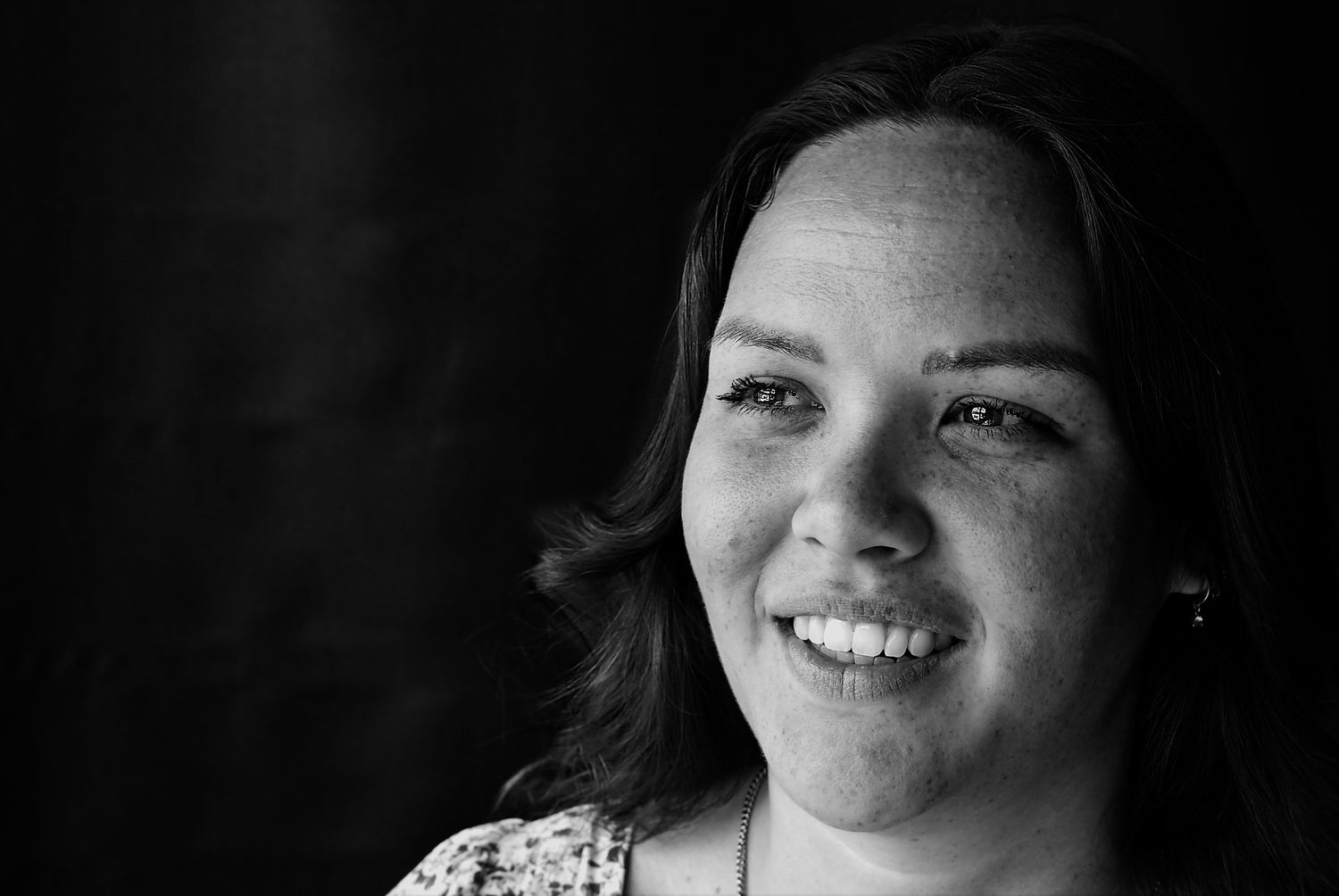 Black and white portrait showing a genuine smile in natural light.