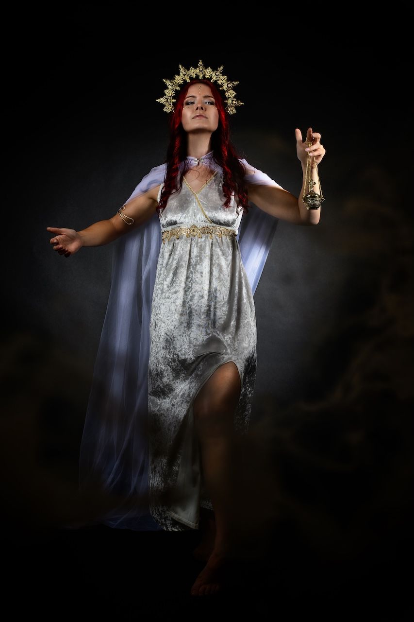 Female Archetypes: Mystical figure in white dress and crown floating ethereally against dark background with dramatic lighting effects.