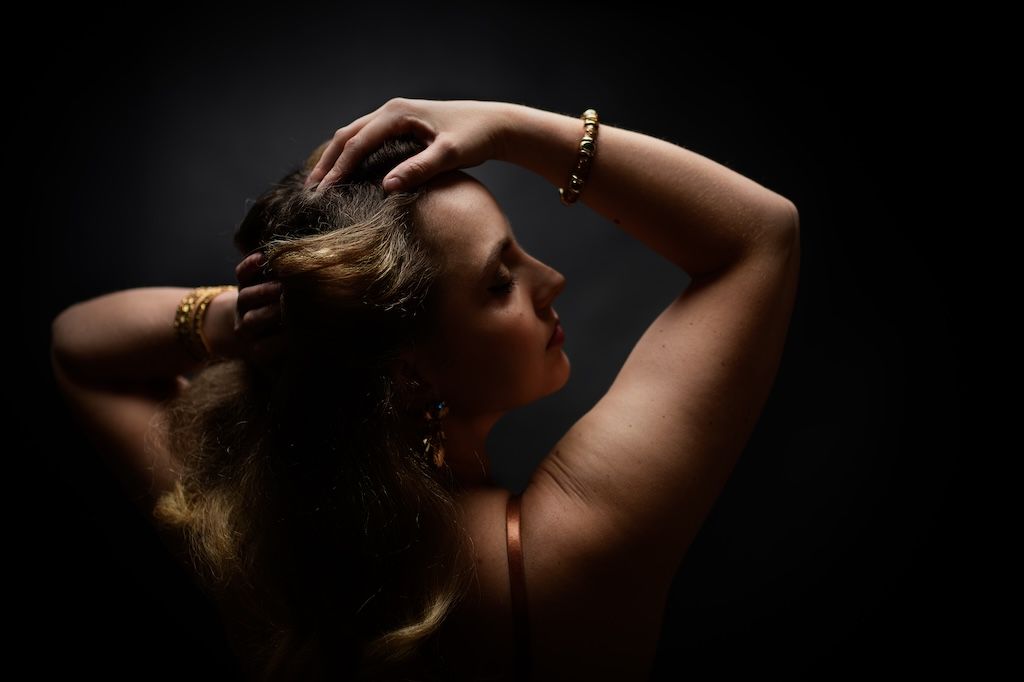 Silhouet boudoirfoto van vrouw met armen omhoog, zeewolde
