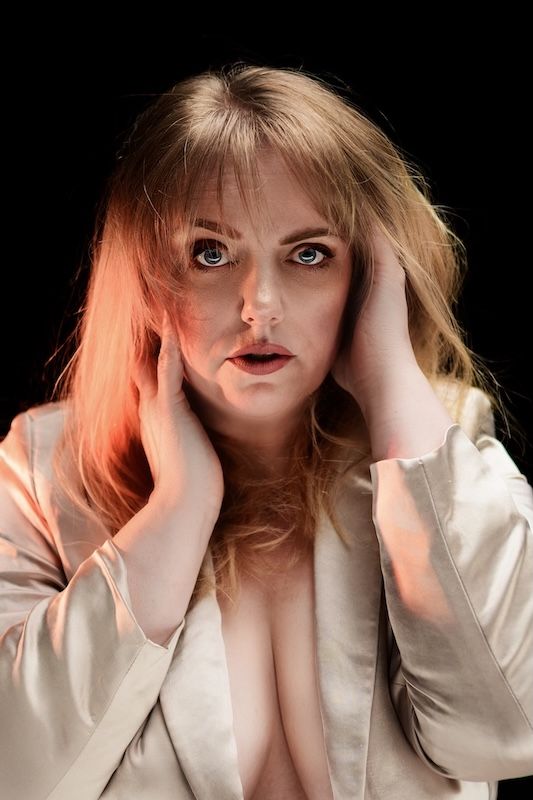 Boudoirfotoshoot in Zeewolde blonde vrouw met enkel gouden jasje aan