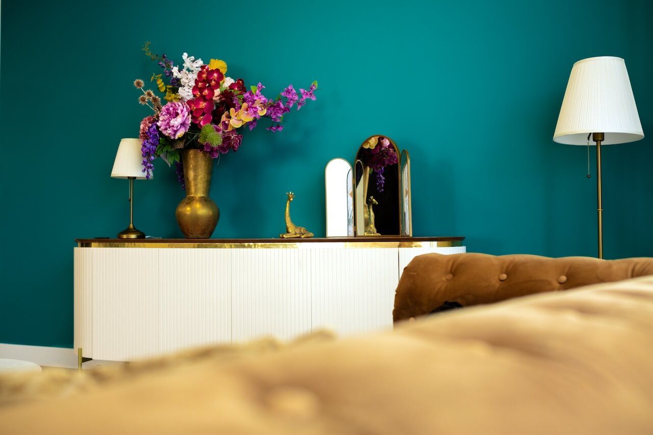Een moderne kamer in groenblauw in daglichtstudio in Zeewolde  kleurrijke bloemstukken