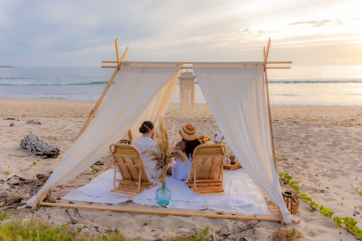 Couple dining under canopy tent on beach at sunset. Guanacaste, Costa Rica