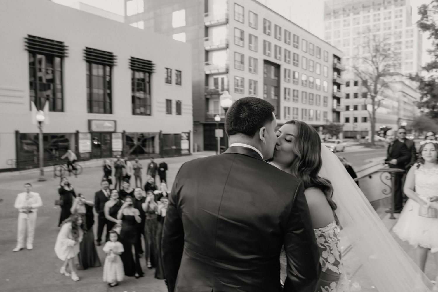 A black and white photographic collage showing a wedding couple kissing in the urban streets of Sacramento.