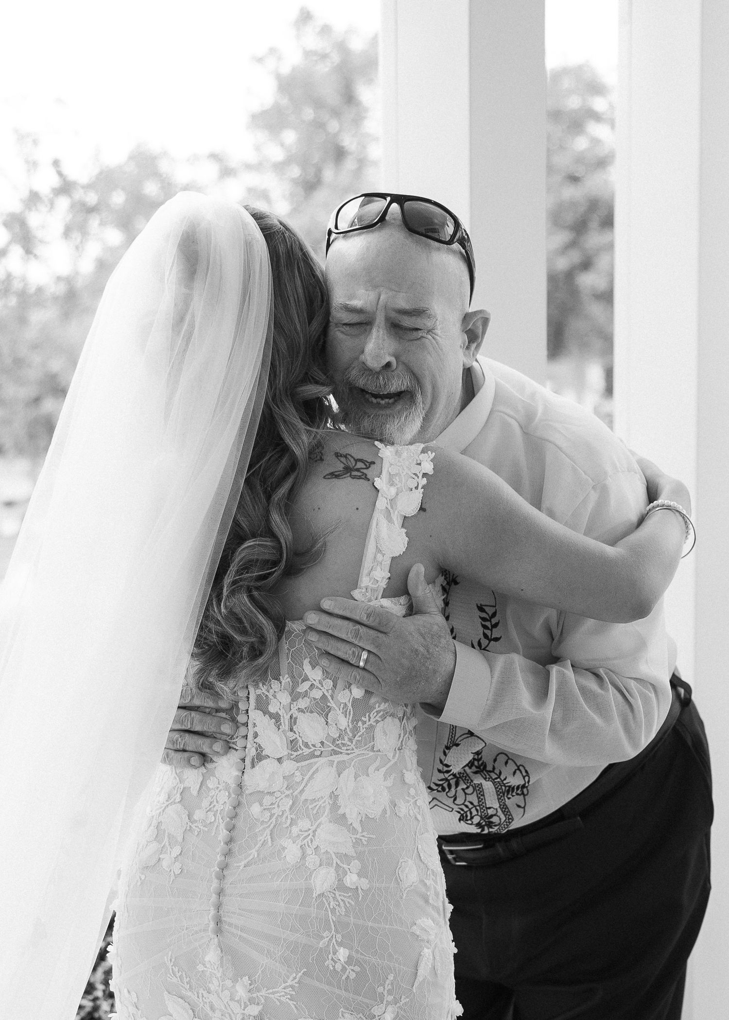 An emotional black and white wedding moment captured between two people during an embrace.