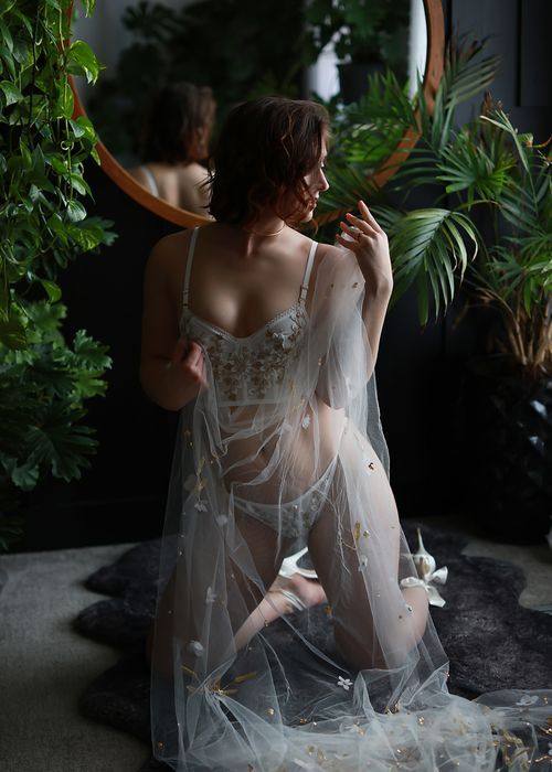 Artistic boudoir photo series showing delicate white sheer robe against lush tropical greenery background.
