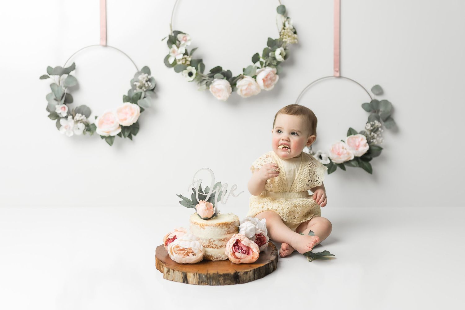A sweet baby girl eating her cake during her cake smash photography session during a cedar park tx cake smash photo shoot