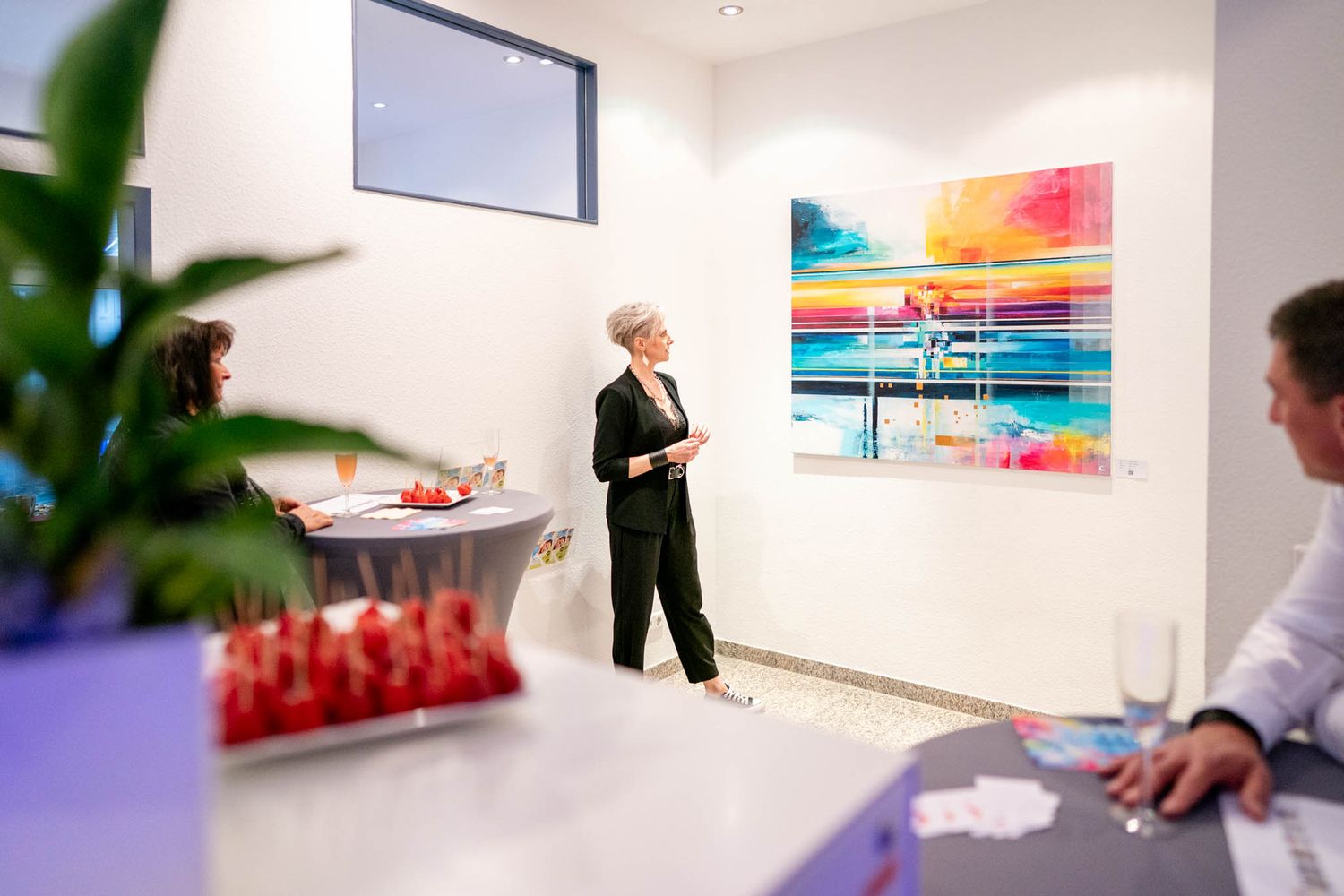 Modern office space with vibrant wall art features colorful abstract paintings and clean white walls.